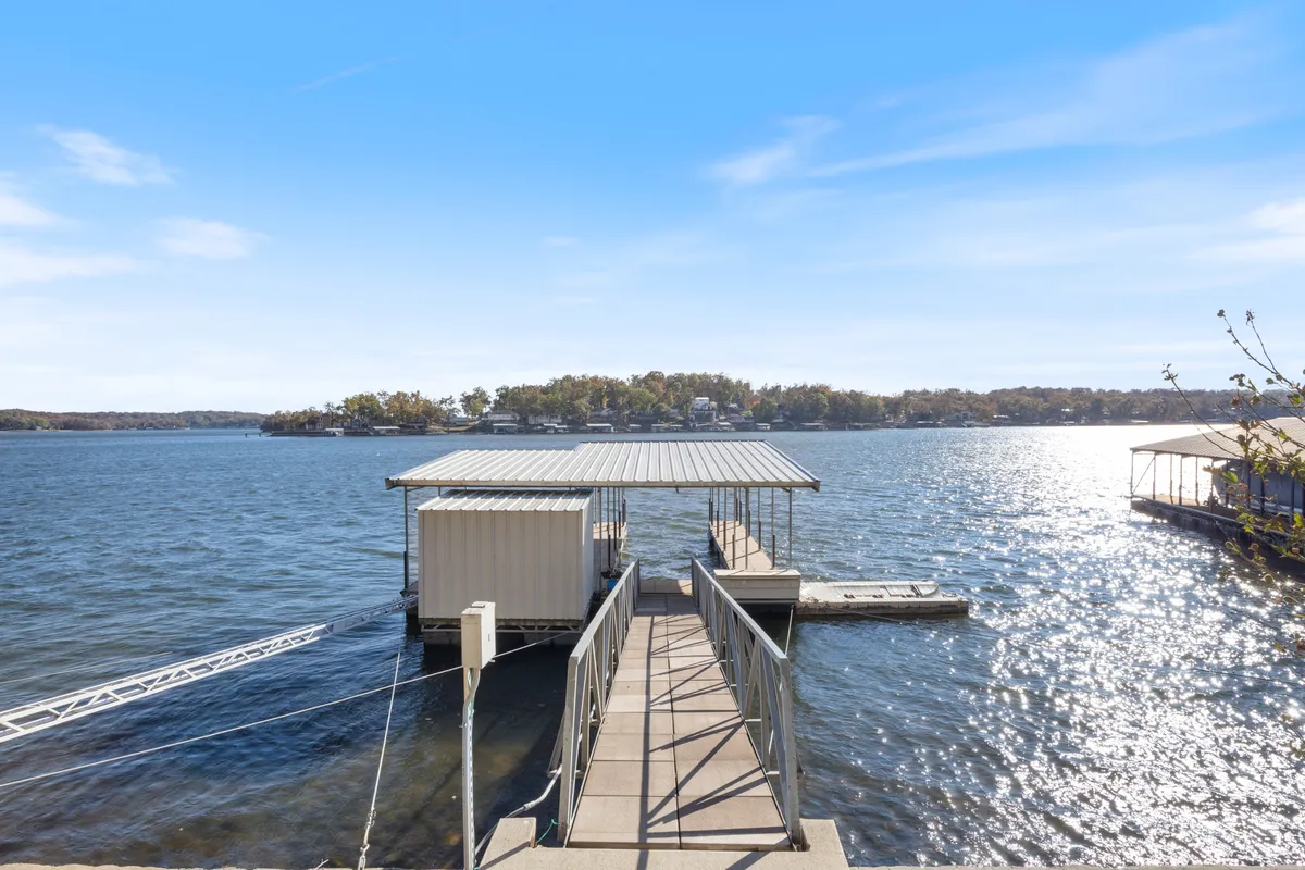 A peaceful view of the dock stretching into the water, with open sky and calm lake reflections. The setting is ideal for boating, fishing, or simply soaking in the waterfront vibe.