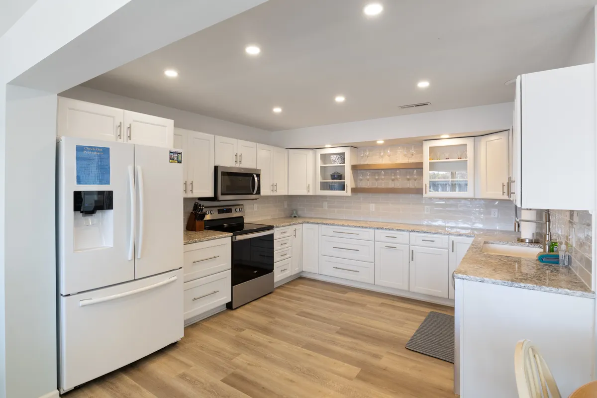 A modern kitchen with stainless steel appliances, granite countertops, and white cabinetry—functional yet stylish. The space is ready for anything from family breakfasts to dinner parties with friends.