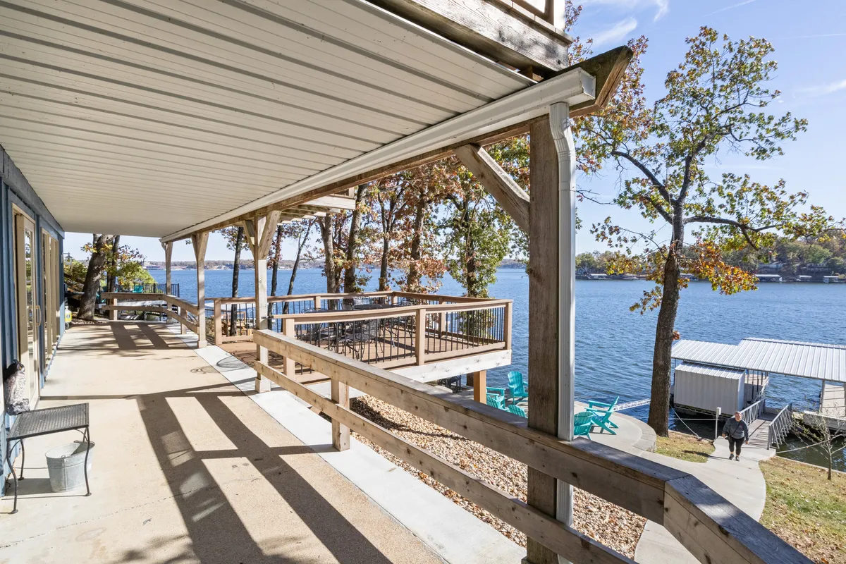 A peaceful wooden deck with comfortable outdoor seating overlooking the lake. The scene includes a sturdy railing, clear views of the water, and a sense of inviting tranquility—well-suited for coffee at sunrise or socializing with friends.